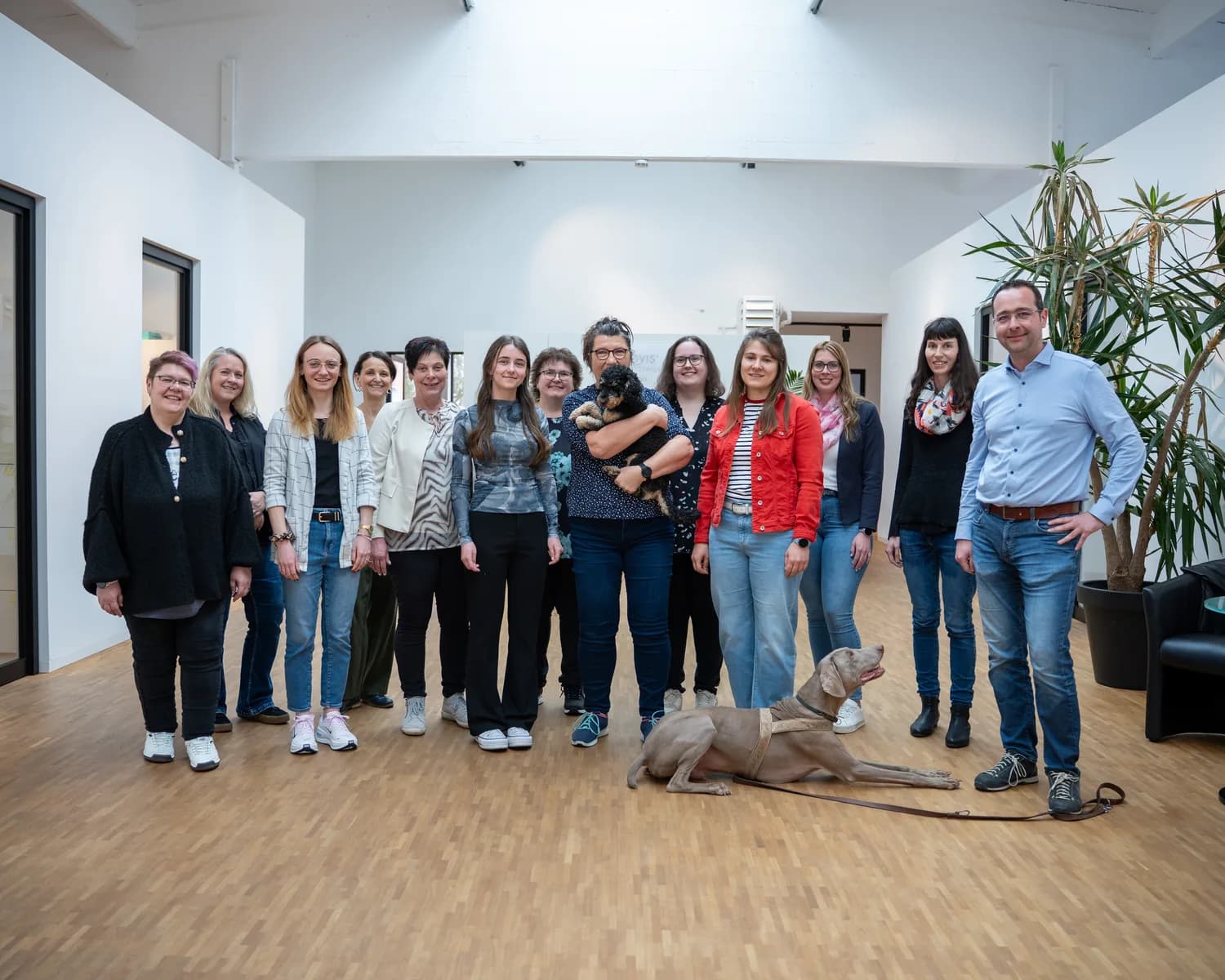 Ein Team steht gemeinsam in einer hellen Bürohalle